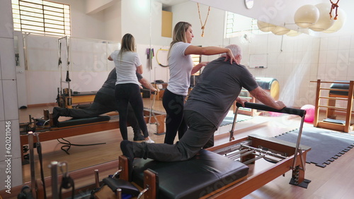 Pilates Instructor Guiding Senior Man, Physiotherapy Session with Exercise Machine