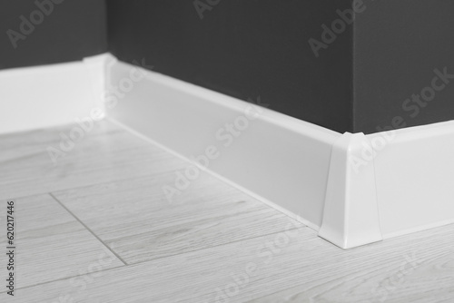 Canvas Print White plinth with connector on laminated floor near black wall indoors, closeup