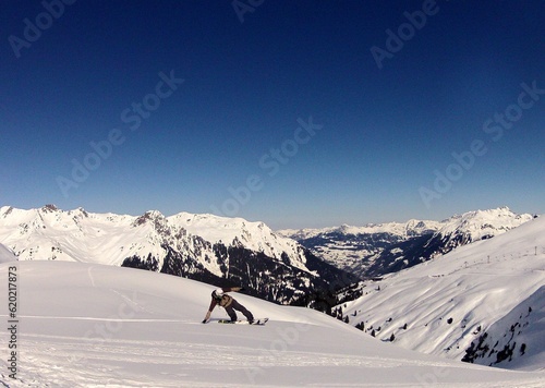 snowboarders in snow with sun and blue sky with clouds