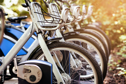 Bike Sharing System. Electric Bicycles or e bikes Charging in Public Parking lot. Modern Blue Bikes with Basket for Rental Service. Eco Transport concept