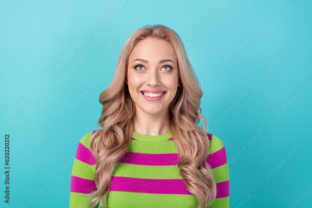 Photo portrait of attractive young woman look up empty space wear trendy striped clothes isolated on cyan color background Photo portrait of attractive young woman look up empty space wear trendy striped clothes isolated on cyan color background