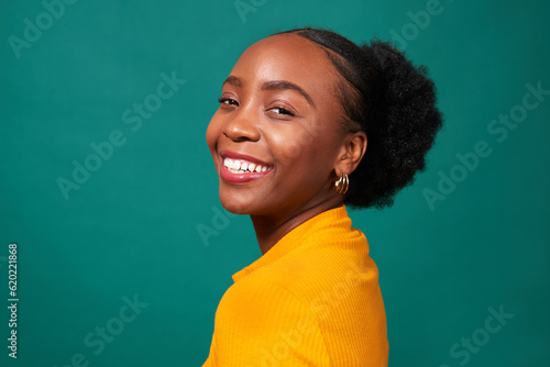 Obraz na płótnie Beautiful Black woman smiles, studio teal background, fashion lifestyle portrait