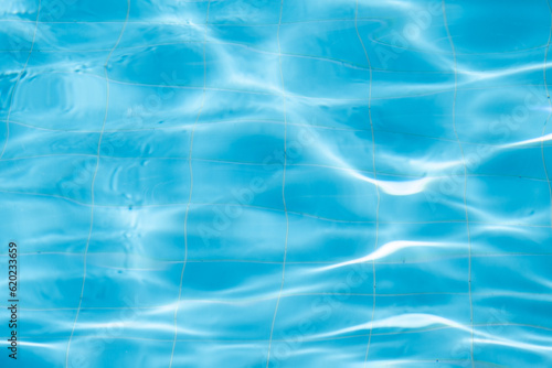 Water background, ripple and flow with waves. Summer blue swiming pool pattern. Sea, ocean surface. Overhead top view with place for text.