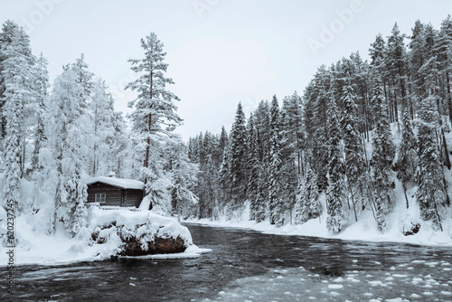 Snow-covered hut by  river in the Oulanka National Park, Finland © Valentina