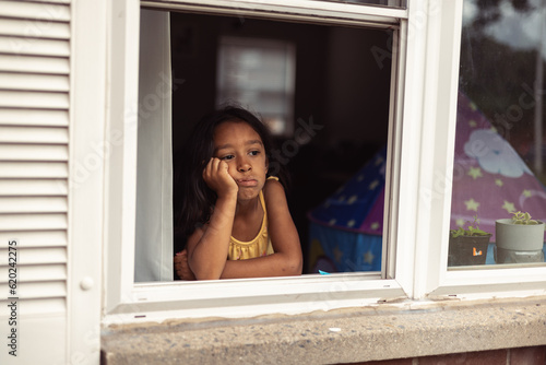 Εκτύπωση καμβά diverse child at home looking out window, lonely bored and sad