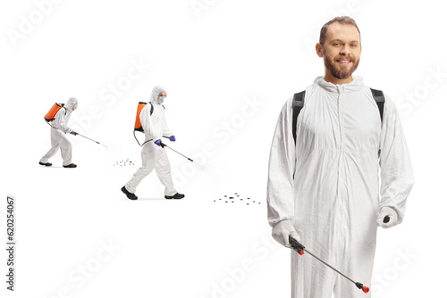 Pest control professionals in white suits spraying insects