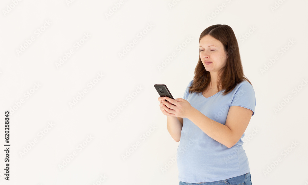 Portrait of a smiling cute pregnant woman using mobile phone isolated on a white background Portrait of a smiling cute pregnant woman using mobile phone isolated on a white background