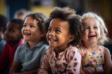 Mixed race group of happy toddlers, sitting in classroom and looking at their teacher.