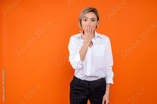 Shocked woman wearing white official style shirt covering mouth