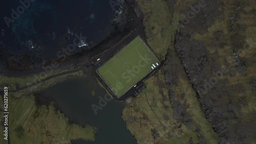 high altitude aerial view of soccer field on the coast at Eysturoy.