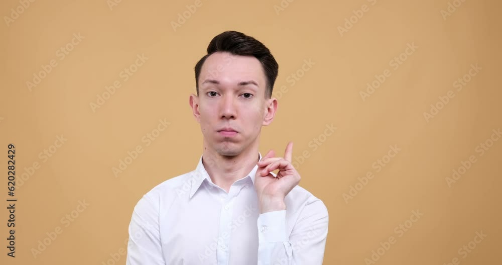 contemplative Caucasian man stands against a serene beige background. With a pensive expression, he engages in deep thought. Suddenly, he pointing up his finger and have brilliant idea. contemplative Caucasian man stands against a serene beige background. With a pensive expression, he engages in deep thought. Suddenly, he pointing up his finger and have brilliant idea.