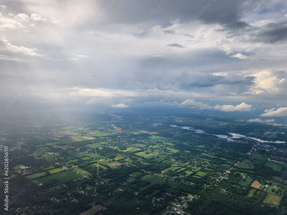 farmland from above lit by sunshine through clouds