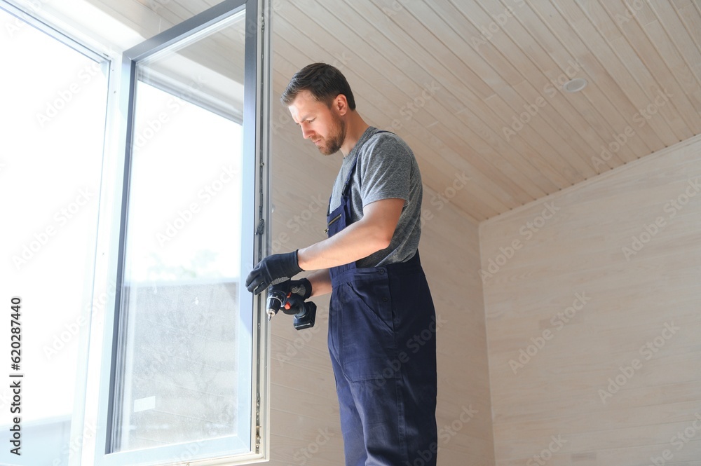 A worker installs windows in a new modular home. The concept of a new home.