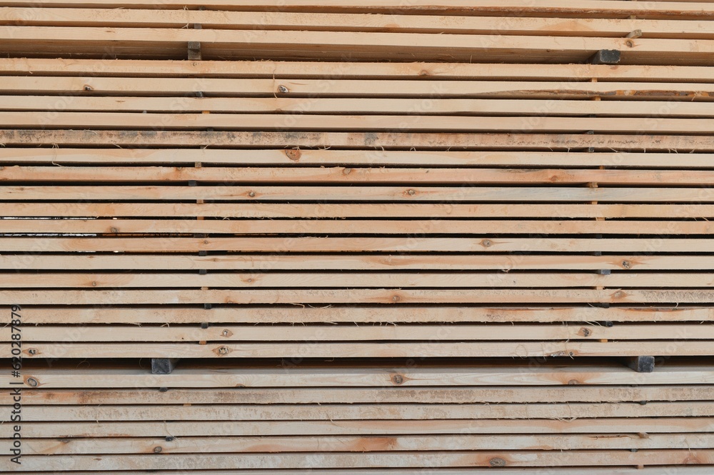 stacked wooden boards in a woodworking industry. stacks with pine lumber. folded edged board. wood harvesting shop. timber for construction. stacked wooden boards in a woodworking industry. stacks with pine lumber. folded edged board. wood harvesting shop. timber for construction.