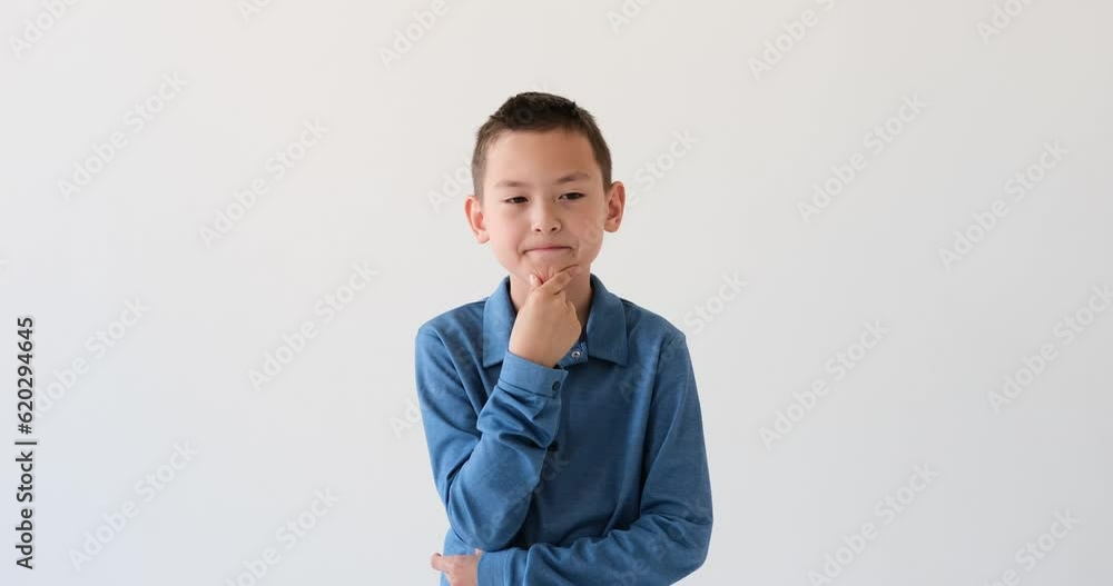 Asian schoolboy engages in deep thought, carefully contemplating his options against a pristine white backdrop. With a furrowed brows, he weighs the pros, reflecting on the decision before him. Asian schoolboy engages in deep thought, carefully contemplating his options against a pristine white backdrop. With a furrowed brows, he weighs the pros, reflecting on the decision before him.