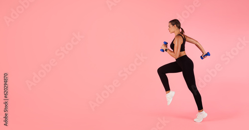 Sport Motivation. In Motion Shot Of Sporty Young Woman Running With Dumbbells