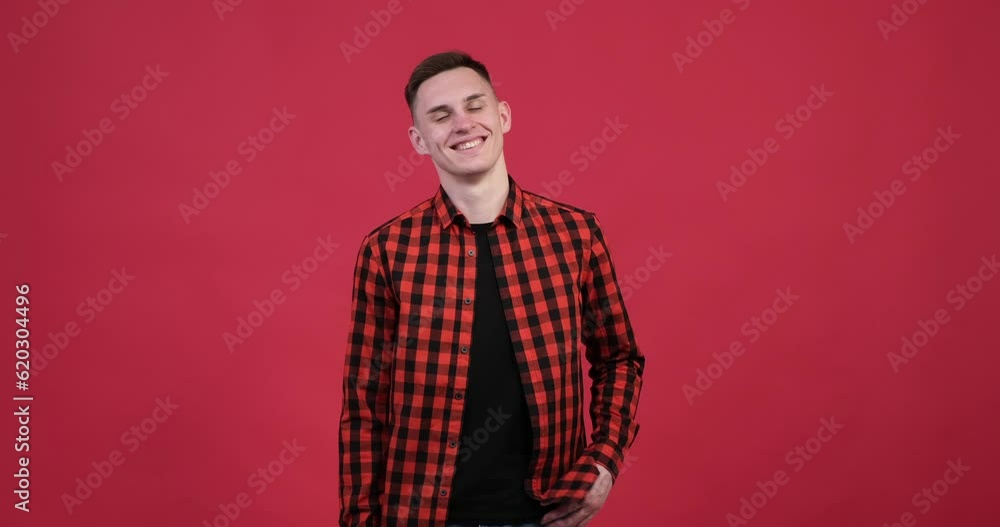 On a red background, a smiling Caucasian man looks directly into the camera with warmth and positivity. His face is lit up with a genuine and infectious smile, radiating happiness and friendliness. On a red background, a smiling Caucasian man looks directly into the camera with warmth and positivity. His face is lit up with a genuine and infectious smile, radiating happiness and friendliness.