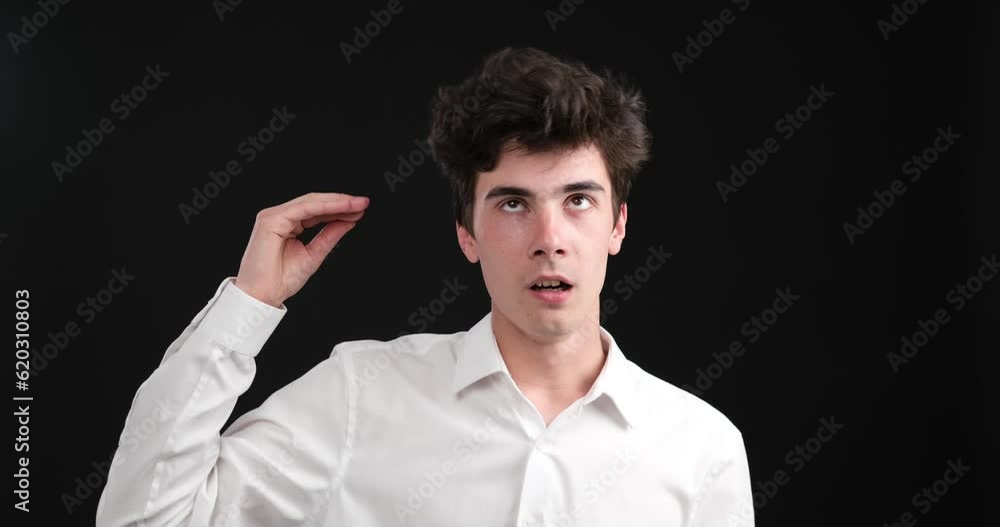 Bored Caucasian man on black background, expressing his boredom through a blah blah gesture. With a disinterested expression, he raises hand, forming the shape of an exaggerated blah blah gesture. Bored Caucasian man on black background, expressing his boredom through a blah blah gesture. With a disinterested expression, he raises hand, forming the shape of an exaggerated blah blah gesture.
