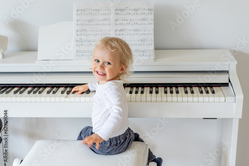  Smiling child playing piano.