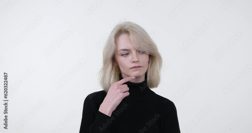 Caucasian woman standing against a white background, deep in thought and contemplation. With her pensive expression and serene posture, she showcases profound inner introspection. Caucasian woman standing against a white background, deep in thought and contemplation. With her pensive expression and serene posture, she showcases profound inner introspection.