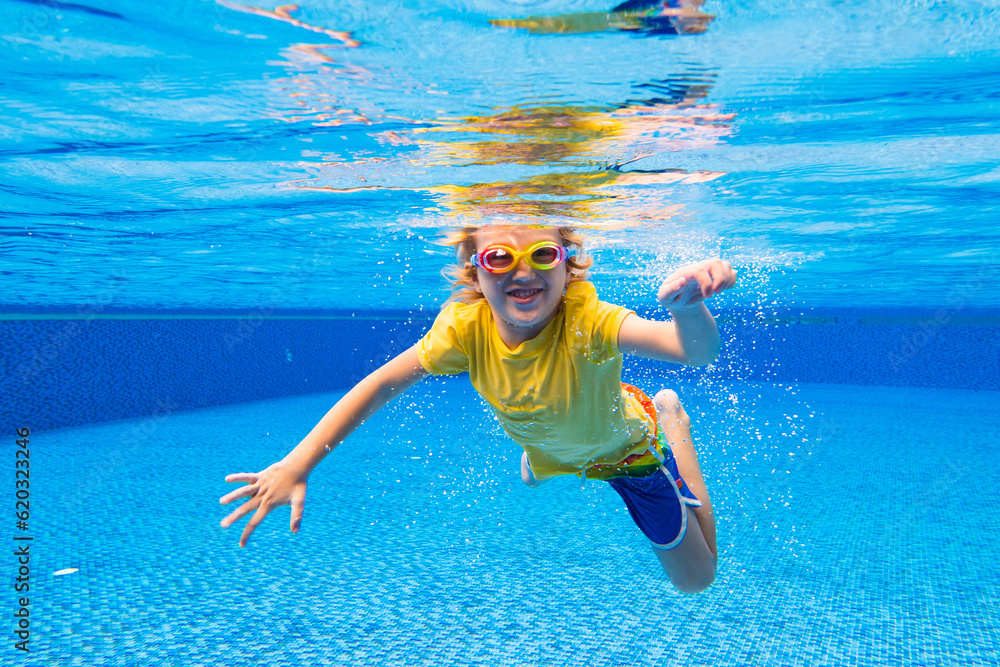 Child underwater in swimming pool. Kids swim.