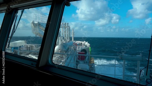 Ship in storm. View from bridge. Splashes from waves at bow of tanker. Strong pitching.