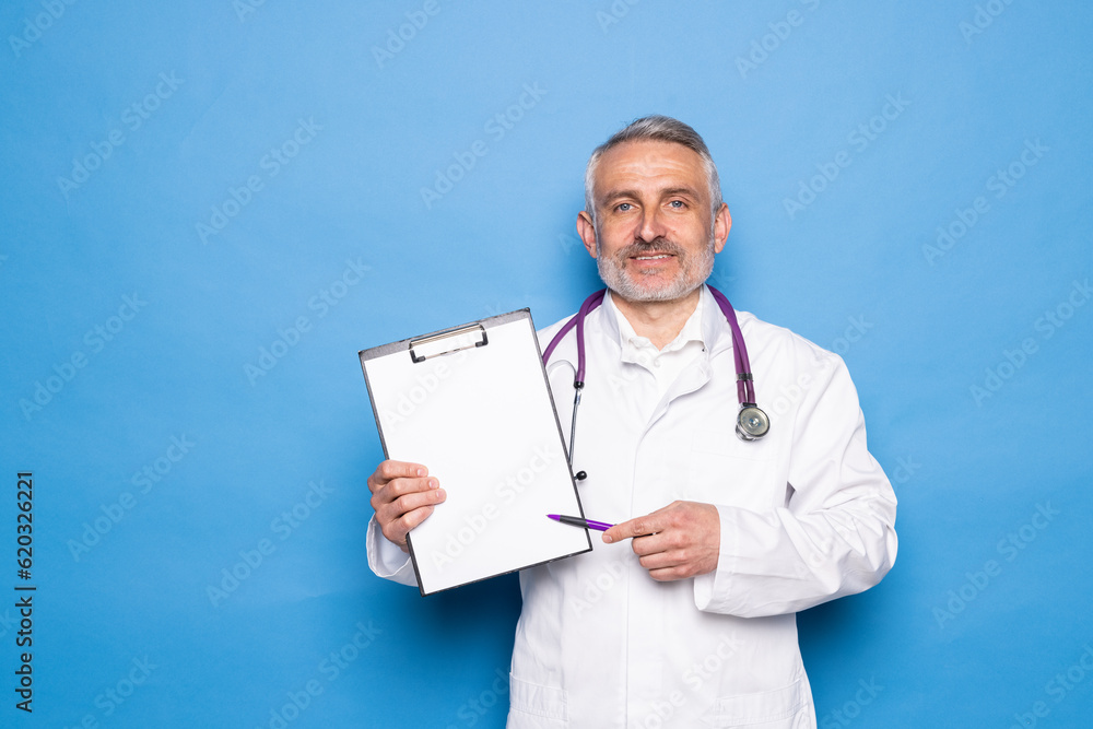 Middle age man doctor standing with relaxed expression reading document over isolated blue background Middle age man doctor standing with relaxed expression reading document over isolated blue background