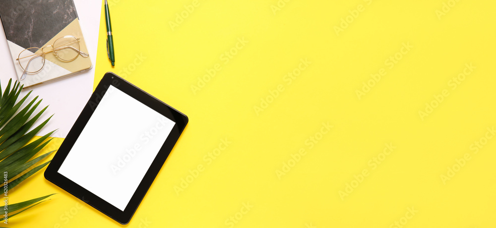 Modern tablet computer, eyeglasses and office stationery on yellow background with space for text Modern tablet computer, eyeglasses and office stationery on yellow background with space for text
