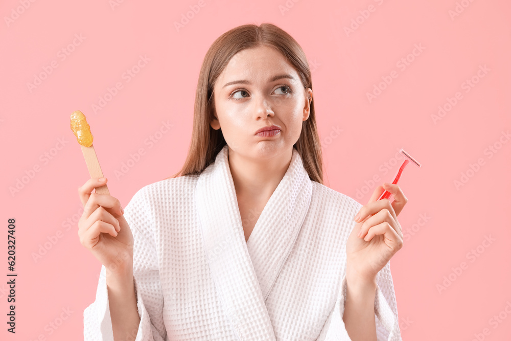 Thoughtful young woman choosing between shaving and sugaring on pink background - obrazy, fototapety, plakaty 