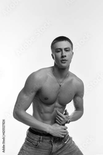 A young, sexy, athletically built man with no shirt on a gray and white background. photo