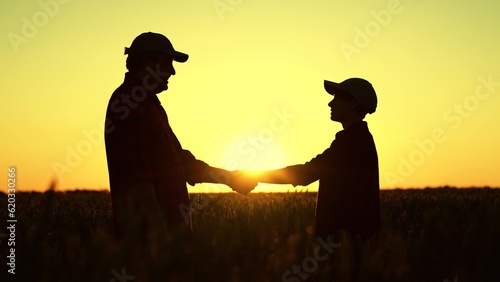 two farmers shake hands wheat field. business deal wheat ear sunset field. agriculture concept. teamwork group people. silhouette handshake farm sunset. teamwork farmer engineer wheat dawn. handshake
