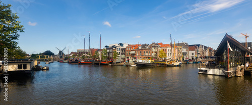 Quay with moored ships along Oude Rijn river in Leiden, Netherlands.