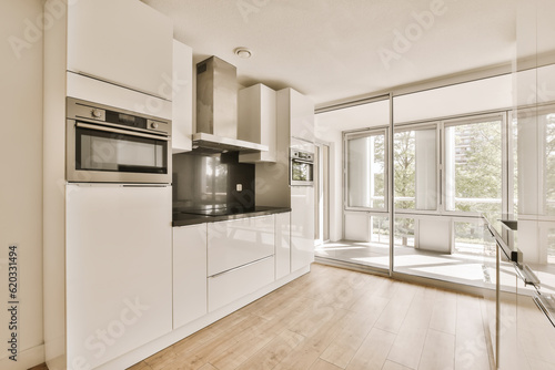 a kitchen with white cabinets and black appliances on the counter top in front of the window looking out to the outside