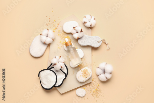 Composition with bottle of essential oil  bath supplies and cotton flowers on color background