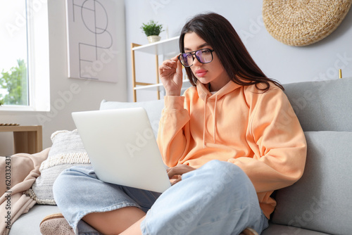 Young woman with laptop wea...