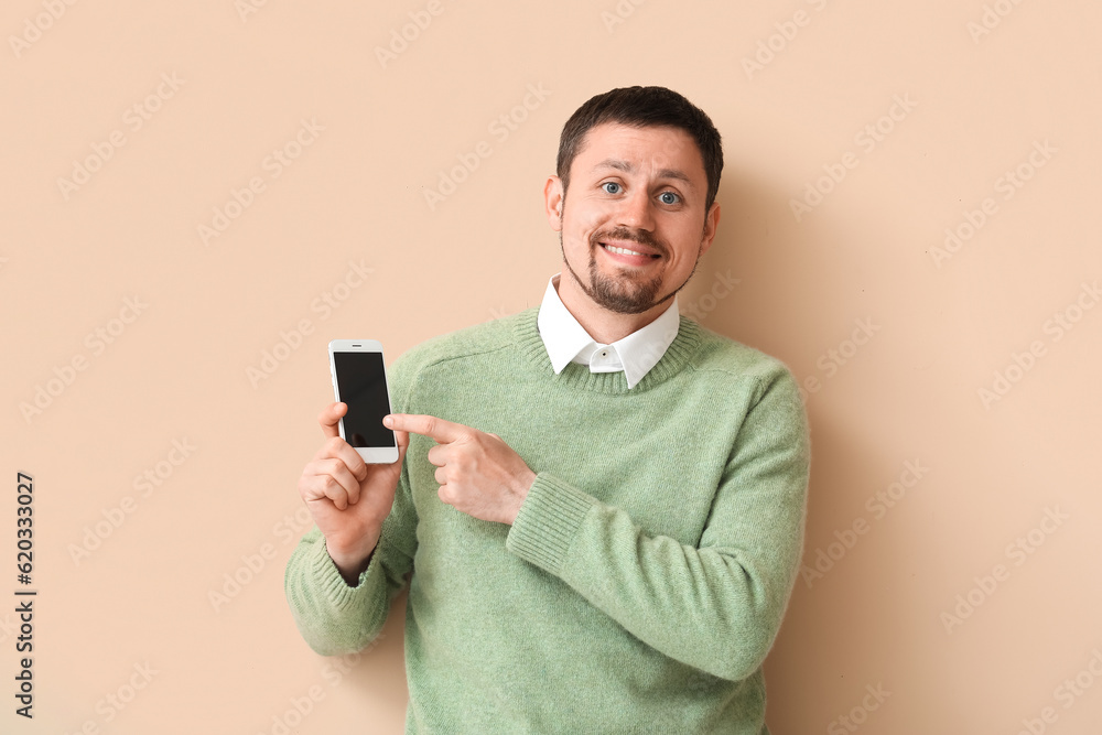 Happy man with smartphone on beige background Happy man with smartphone on beige background