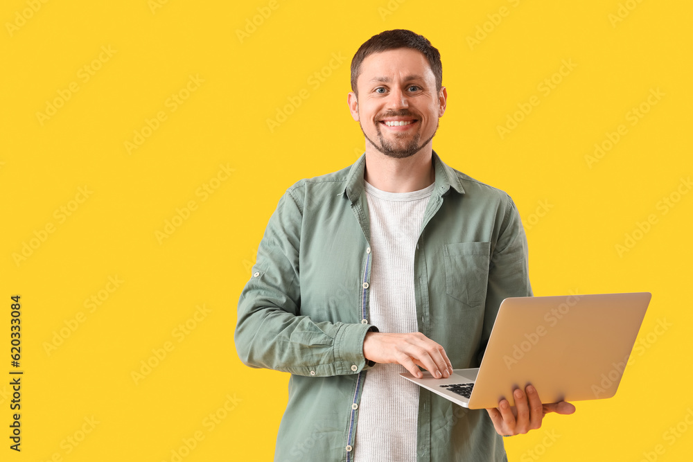 Man with laptop on yellow background Man with laptop on yellow background
