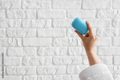 Hand with soap on white brick background © Pixel-Shot