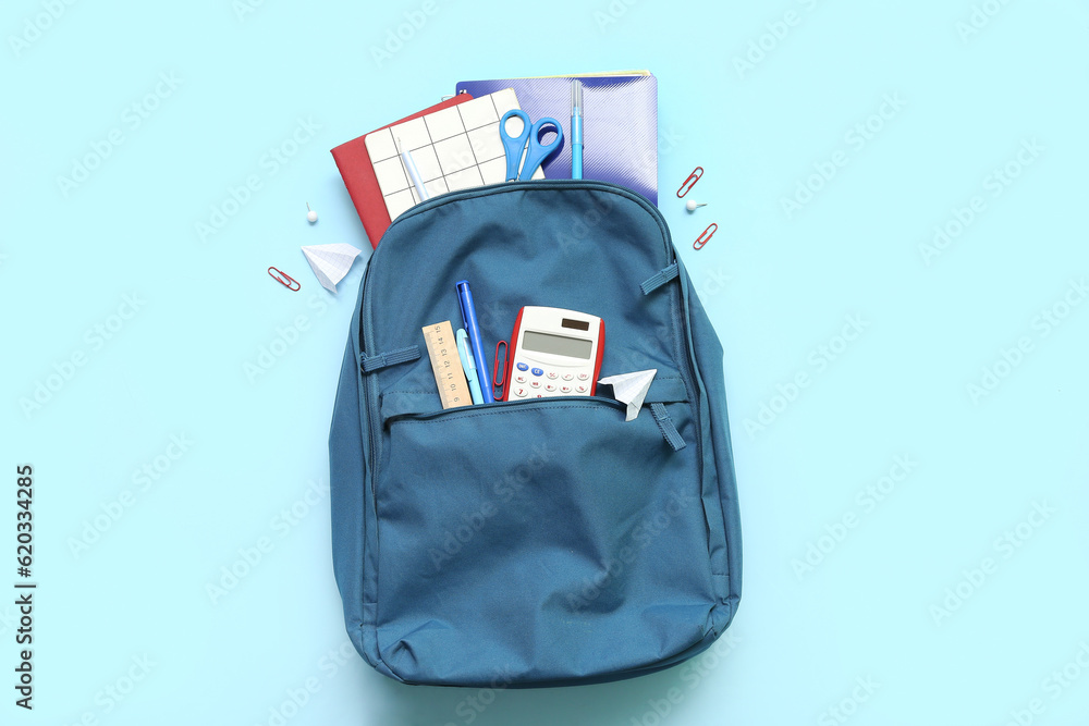 Naklejka premium School backpack with different stationery on blue background
