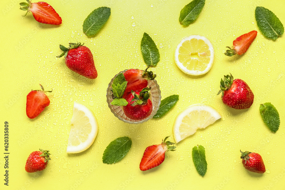 Glass of fresh lemonade with strawberry and lemon on yellow background Glass of fresh lemonade with strawberry and lemon on yellow background