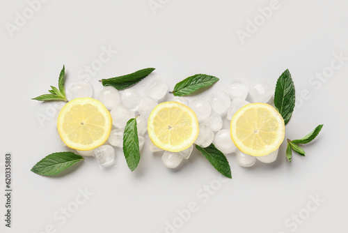 Lemon slices with ice cubes and mint on white background