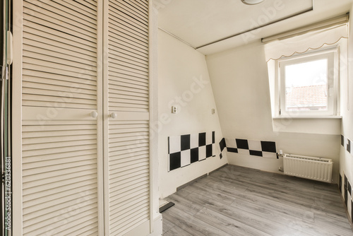 a bathroom with black and white tiles on the walls  wood flooring and an open door leading to another room