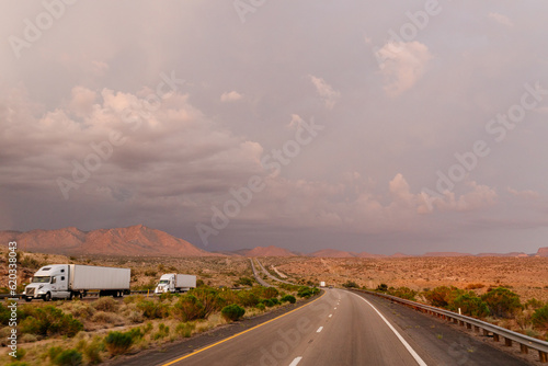 A beautiful asphalt road among hills with dry grass. A scenic landscape with highway, mountains on background and blue sky with fluffy clouds on sunny day. Phoenix, AZ, USA - 7-22-2021