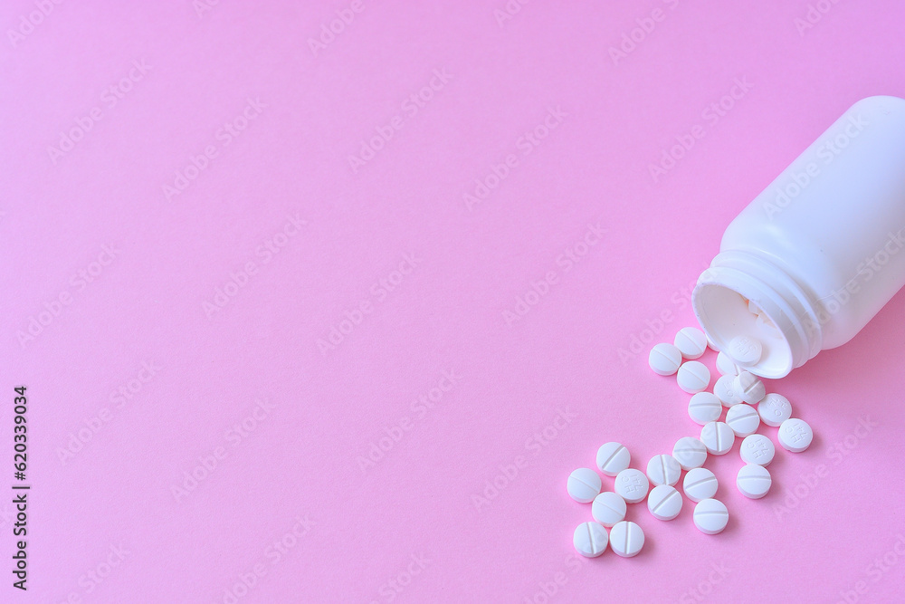 ピンクの背景と白い錠剤と薬のボトル ピンクの背景と白い錠剤と薬のボトル