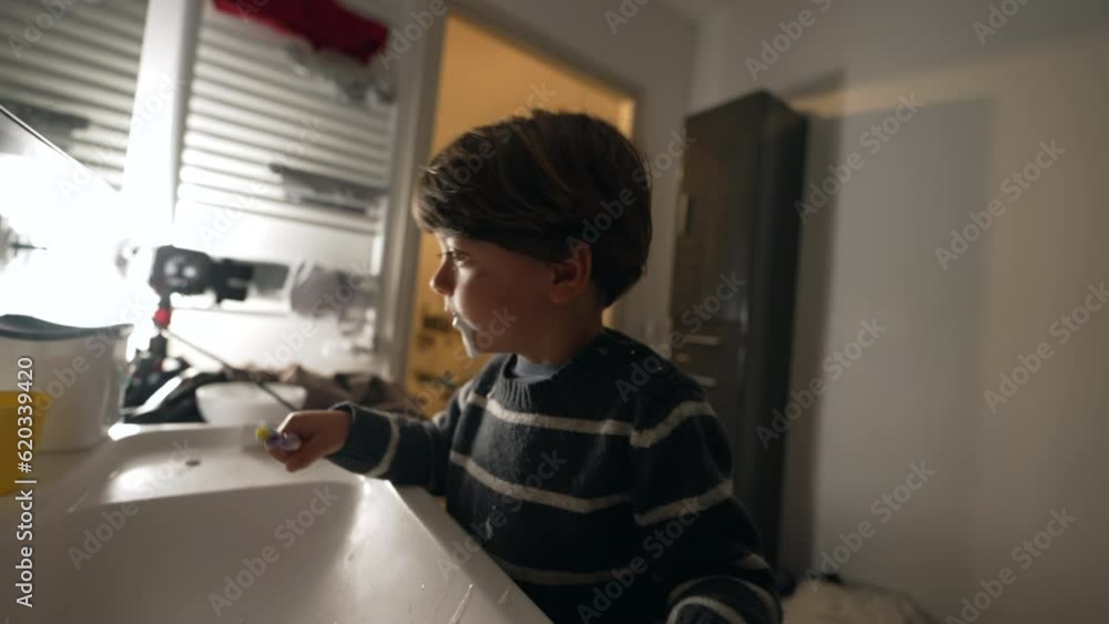 Child brushing teeth at night routine. One small boy spitting in bathroom sink Child brushing teeth at night routine. One small boy spitting in bathroom sink