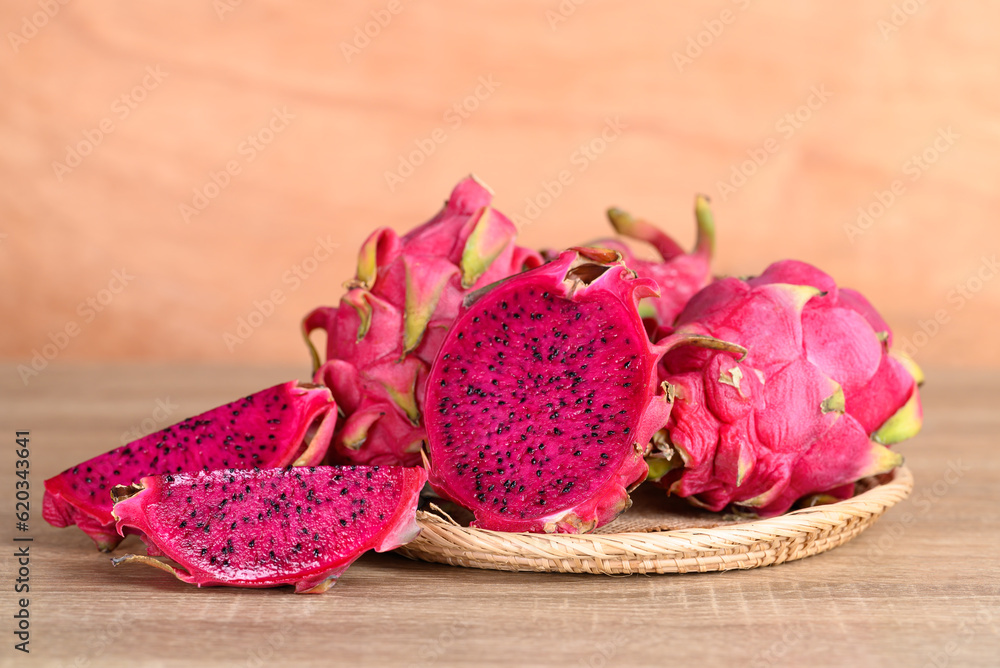 Red dragon fruit or pitaya in basket on wooden background, Tropical fruit in summer season Red dragon fruit or pitaya in basket on wooden background, Tropical fruit in summer season