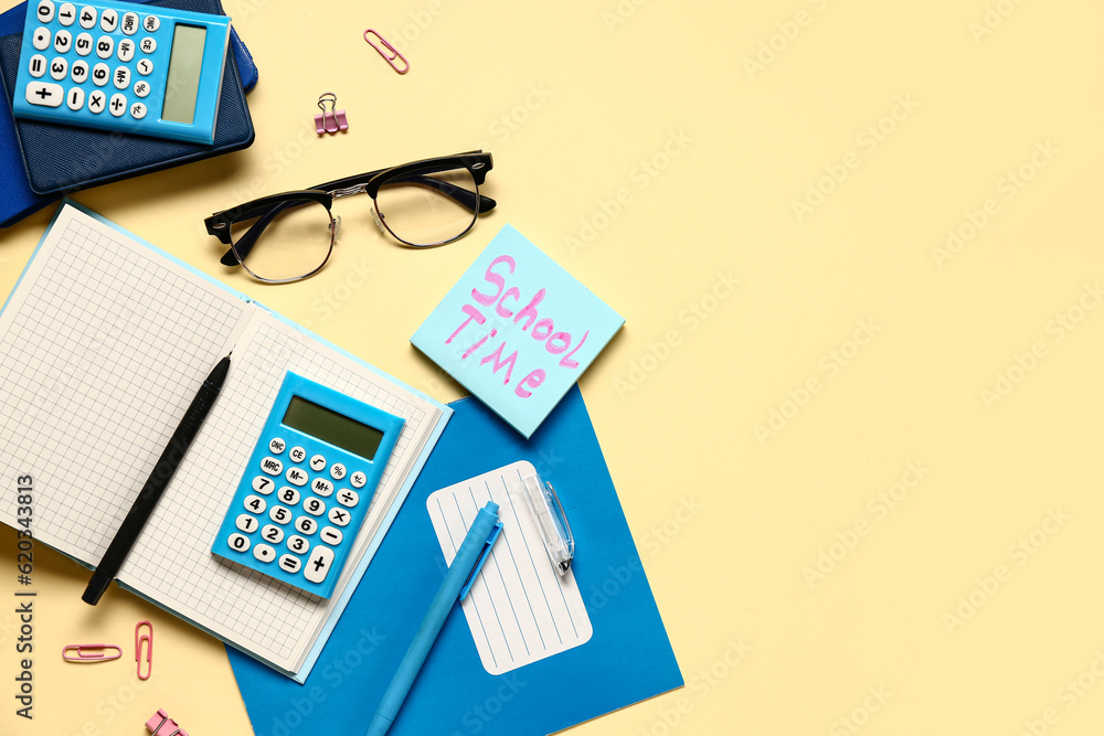 Sticky note with text SCHOOL TIME, stationery and calculator on pale yellow background Sticky note with text SCHOOL TIME, stationery and calculator on pale yellow background