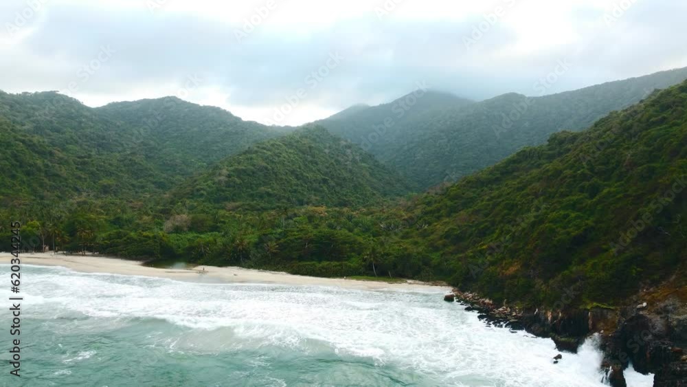 Cloudy day on a tropical beach with mountains covered in jungle, Caribbean Sea coast, Colombia
