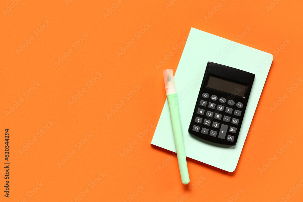 Modern calculator with stationery on orange background Modern calculator with stationery on orange background