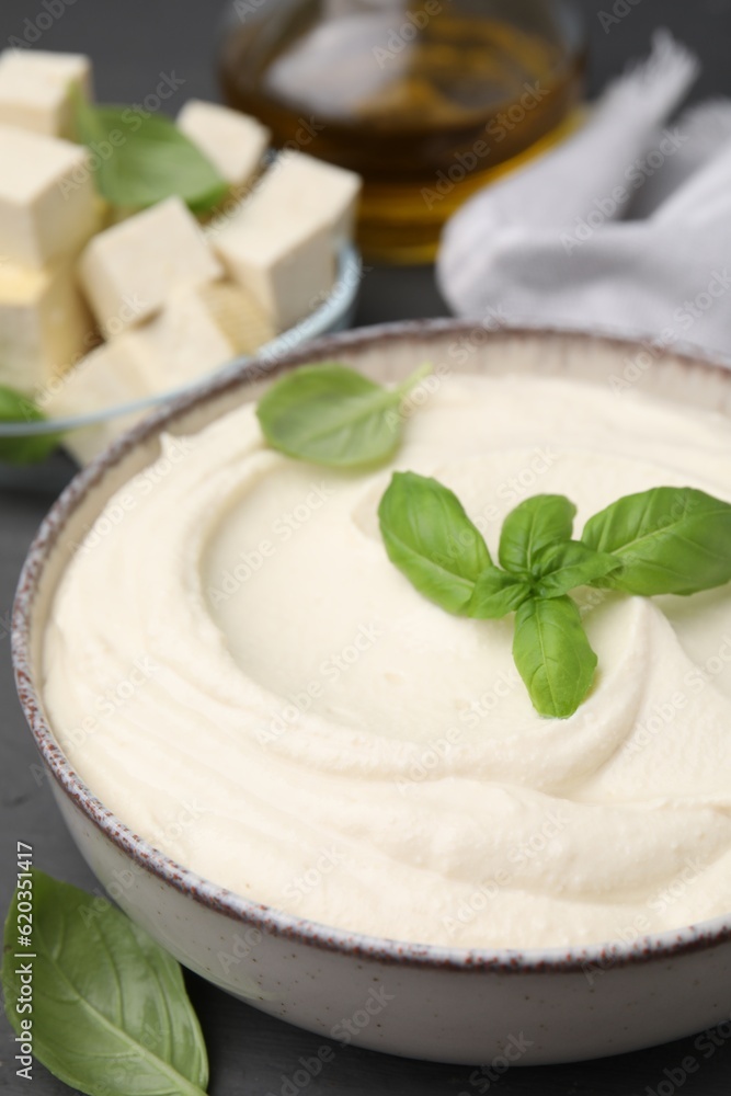Delicious tofu sauce and basil leaves in bowl on grey table, closeup Delicious tofu sauce and basil leaves in bowl on grey table, closeup